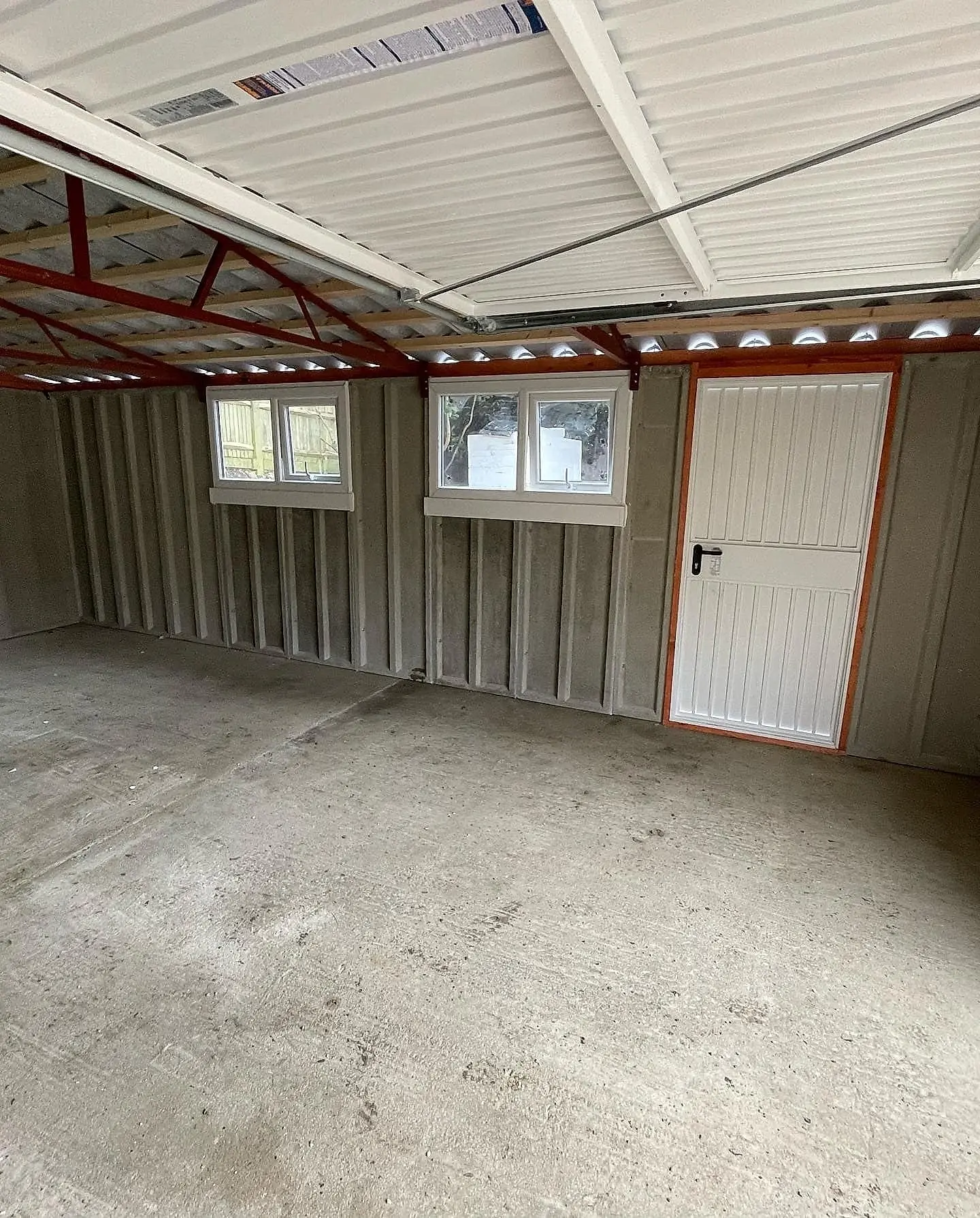 Inside an Apex concrete garage showing the pitched roof trusses and eaves storage