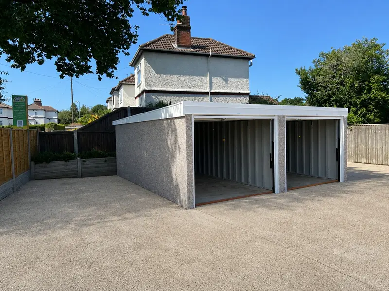 Double pent roof concrete garage with the doors open on a concrete forecourt