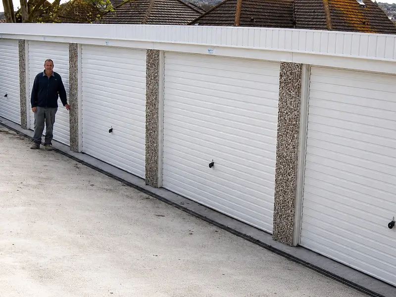 Nucrete project manager standing beside a row of white battery garage doors