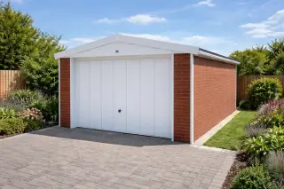 Single garage with red brick-effect cladding, white up-and-over door, and an apex roof