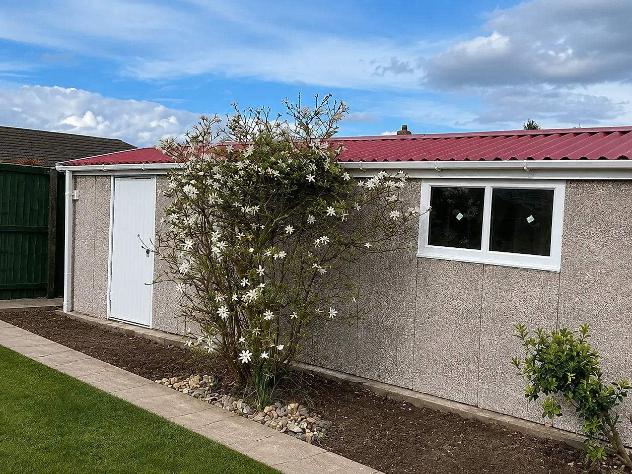 Elite concrete garage side elevation with an apex roof, uPVC window and steel personnel door