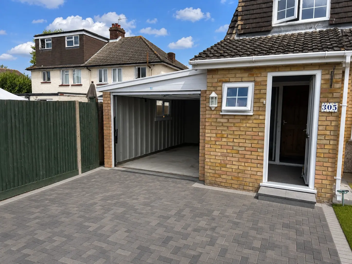Lean-to concrete garage on a block-paved driveway