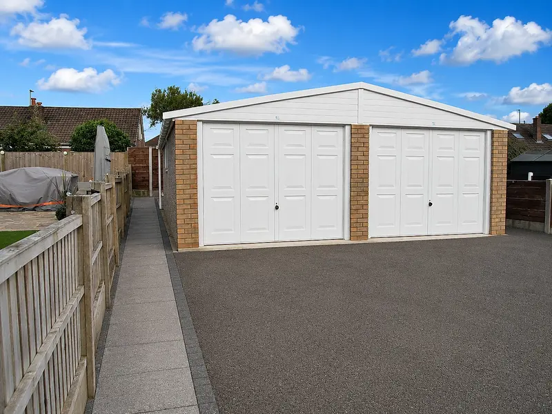 Double Elite concrete garage with white up-and-over doors and real brick pillars under an apex roof