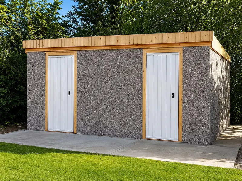 Pent-roof concrete shed with two white personnel doors on a paved base