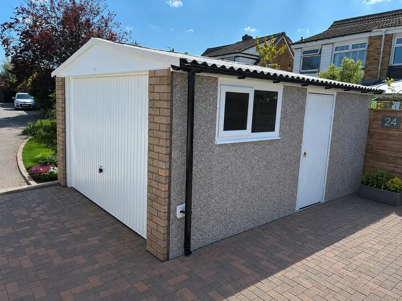 Apex concrete garage with a pebbledash finish on a block-paved driveway