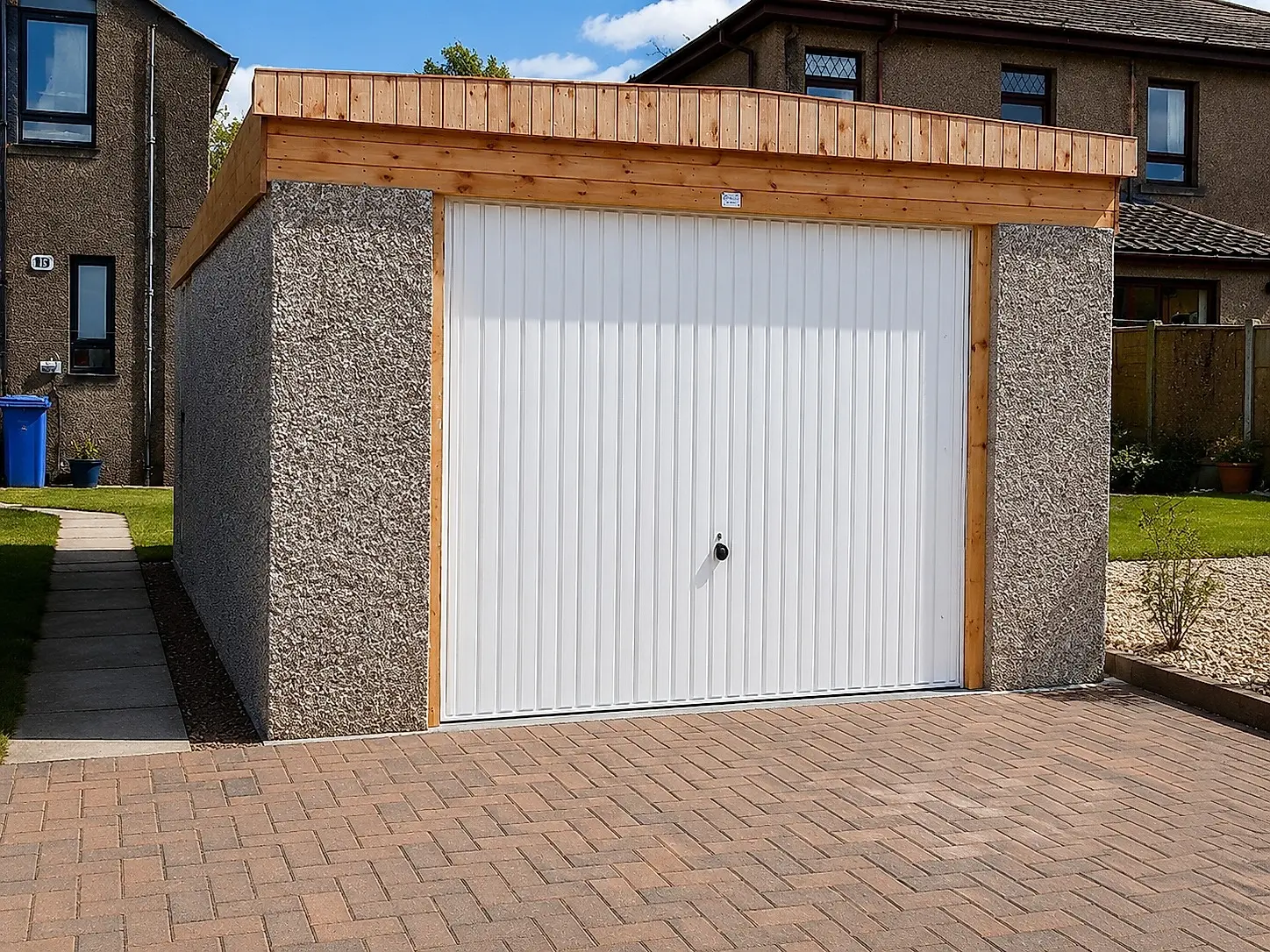 Extra-height pent roof concrete garage with a white up-and-over door and a cedar fascia
