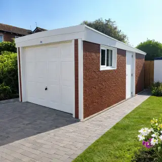 Single garage with red brick-effect panels, white up-and-over door, side window, and flat roof
